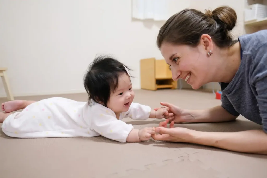 A woman on the floor with a baby